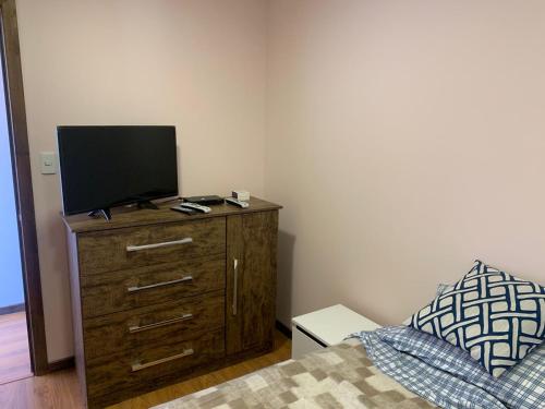 um quarto com uma cama e uma televisão numa cómoda em Patagonia Tower em Puerto Natales