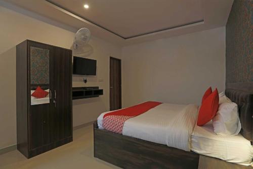 sypialnia z łóżkiem z czerwonymi poduszkami w obiekcie OYO Flagship City Residency w mieście Faridabad