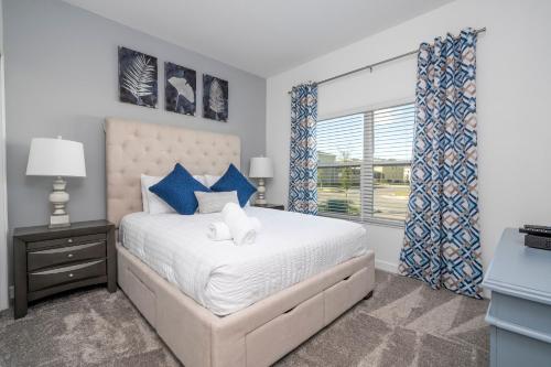 a bedroom with a large bed and a window at NEW to Market 5 Bed - Storey Lake Retreat in Kissimmee