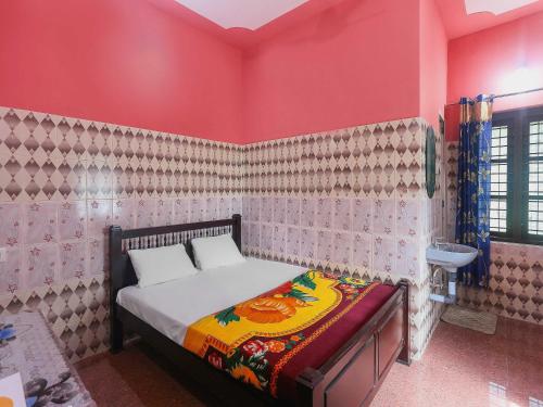 a bedroom with a bed in a pink room at OYO Hotel Sree Bhadra Tourist Home in Kollam
