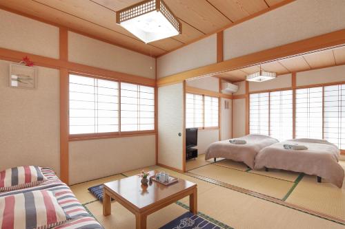 a living room with two beds and a table at Guesthouse Ichigo Ichie Nikko in Nikko