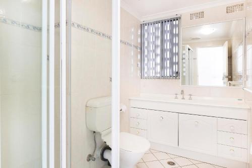 a white bathroom with a toilet and a sink at El Sandi Unit 06 in Forster