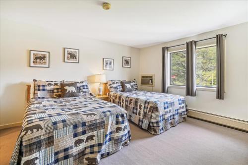 1 dormitorio con 2 camas y ventana en Cedarbrook Deluxe one bedroom suite with outdoor heated pool 21517, en Killington