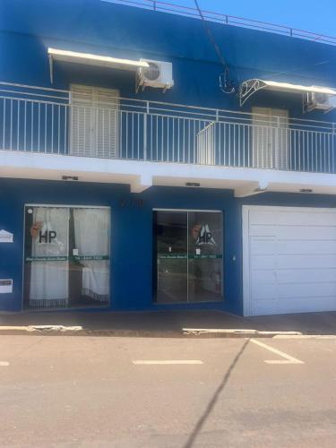 a blue building with two windows and a garage at Hotel Pousada Barra Bonita in Barra Bonita