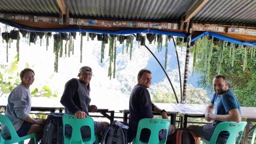 a group of people sitting at a table with icicles hanging from the ceiling at BATAD Rita's Mount View Inn and Restaurant in Banaue