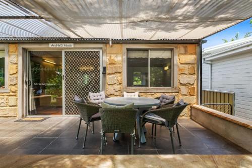 a patio with a table and chairs on a deck at Archie s Abode By Coast Holidays in Patonga Beach