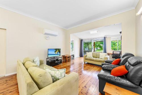 a living room with a couch and a tv at Archie s Abode By Coast Holidays in Patonga Beach
