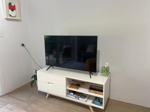 a white entertainment center with a flat screen tv on it at Conjola Inn-let - Self Contained Unit - Lake Conjola in Manyana