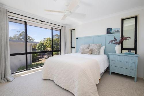 a bedroom with a bed and a large window at Aqua Vistas - Recharge on the Coast in Style in Macmasters Beach