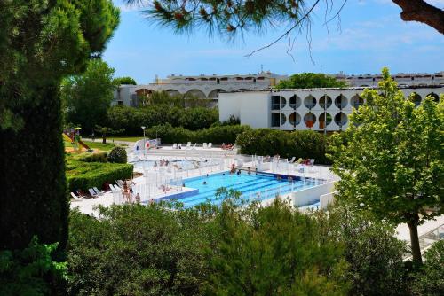 a large swimming pool with people sitting around it at Residence Residéal La Grande Motte in La Grande Motte