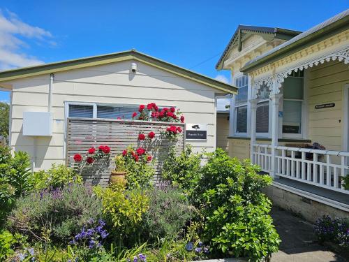 a house with a flower garden in front of it at Turret House in Featherston