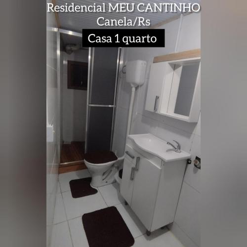 a bathroom with a toilet and a sink at RESIDENCIAL MEU CANTINHO in Canela