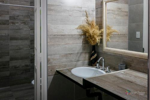 a bathroom with a sink and a mirror at Cabañas Peumayén Salta in San Agustín