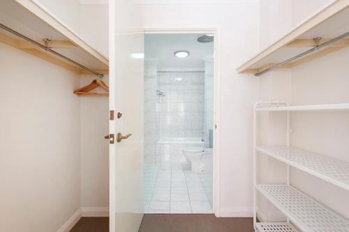 een witte badkamer met een douche en een toilet bij Norfolk Central-balcony View W Bbq & Secure Park in Fremantle