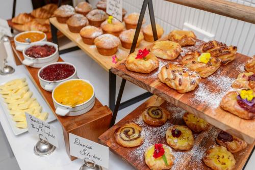 a display of various pastries and breads on wooden boards at Scenic Hotel Cotswold in Christchurch