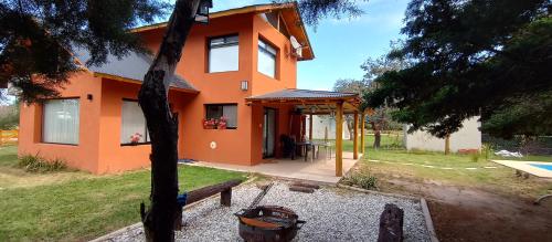 Casa de campo liquidambar في سان بيدرو: منزل برتقالي أمامه طاولة