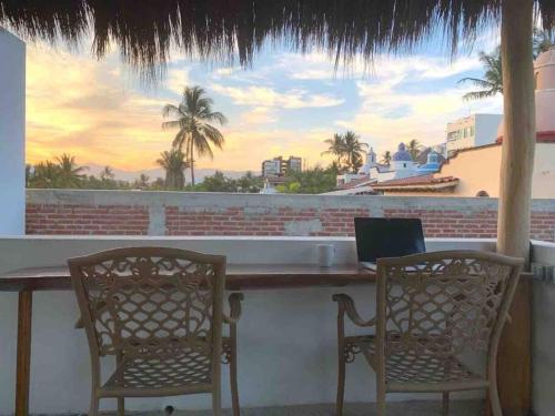 two chairs sitting at a bar with a laptop on it at LAS VUELTAS - 2 Minutes to Beach w/ Pool, Patio & Grill in Bucerías
