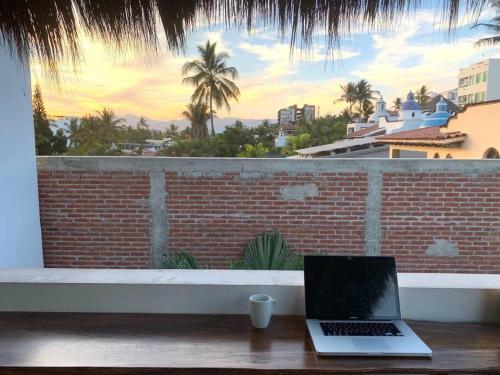 a laptop sitting on a table in front of a window at LAS VUELTAS - 2 Minutes to Beach w/ Pool, Patio & Grill in Bucerías