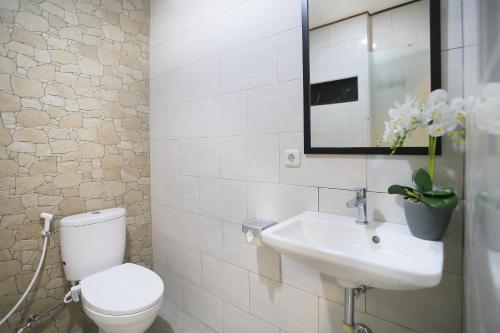 a bathroom with a toilet and a sink and a mirror at ND LOFT 2 by Kasta Hospitality in Canggu