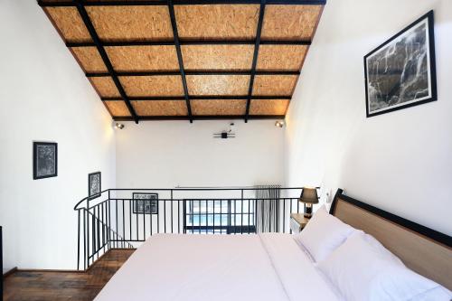 1 dormitorio con cama y techo de madera en ND LOFT 2 by Kasta Hospitality, en Canggu