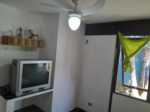 a television sitting on a shelf next to a window at Chalés Recanto da Praia in Caraguatatuba