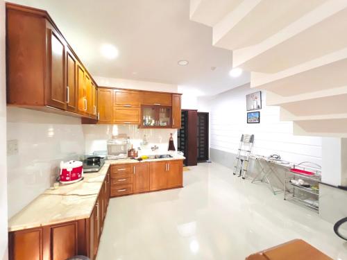 eine Küche mit Holzschränken und einem roten Gerät in der Unterkunft KENPI Homestay in Hue