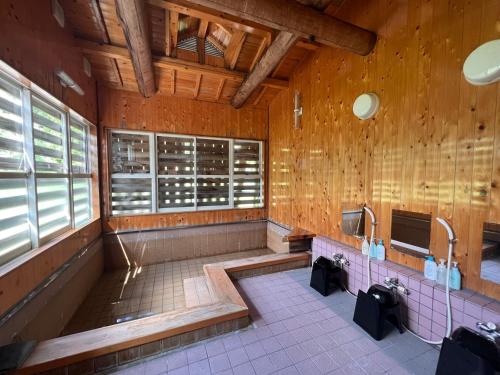 a bathroom with two sinks in a wooden building at AKANE Hostel あかね天然温泉旅館 in Yuzawa