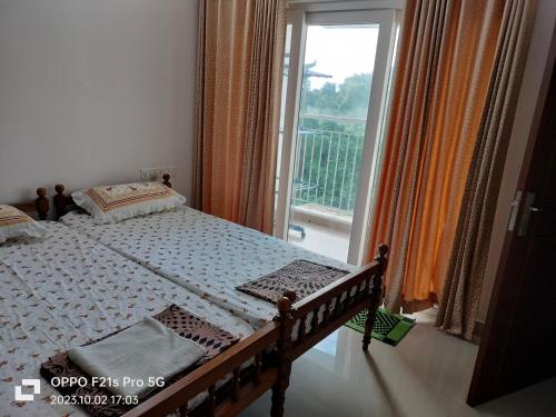 a bedroom with a bed and a large window at Ajith's Inn in Kottayam