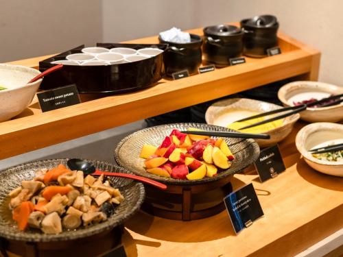 a buffet with bowls of different types of food at Asakusa View Hotel Annex Rokku in Tokyo