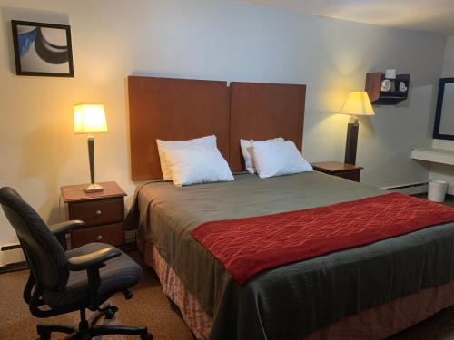 een hotelkamer met een bed en een stoel bij Franklin Motel in Assiniboia