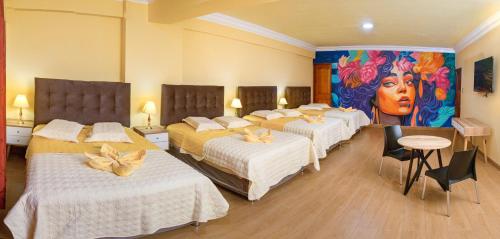 een kamer met drie bedden en een schilderij aan de muur bij Hotel Retamayo in Ica