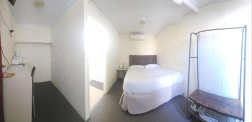 a small bedroom with a bed and a shower at Broken Hill Hotel in Boulder