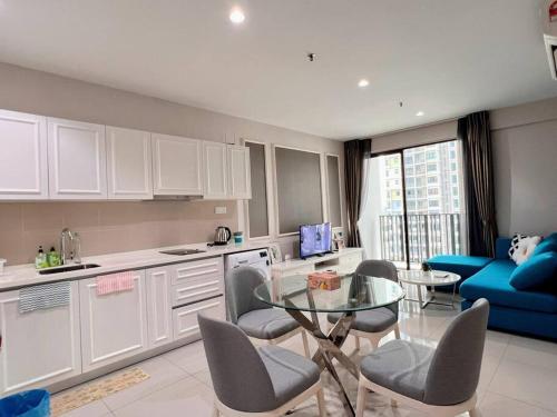 莎阿南的住宿－Homely 2BR, Free Carpark @ Direct Link Central Mall, SOGO, Theme Park，厨房配有玻璃桌和蓝色沙发