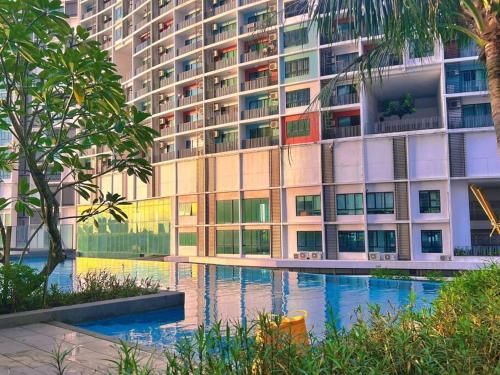 um grande edifício com uma piscina em frente em Homely 2BR, Free Carpark @ Direct Link Central Mall, SOGO, Theme Park em Shah Alam