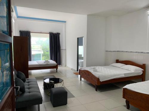 una camera con letto e divano, un letto e un soggiorno di Khách Sạn Homesaty KV2 a Bình Thủy