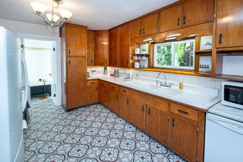 a large kitchen with a sink and a microwave at Vintage downtown flat near Holy Hill, Golf &Ski in Hartford