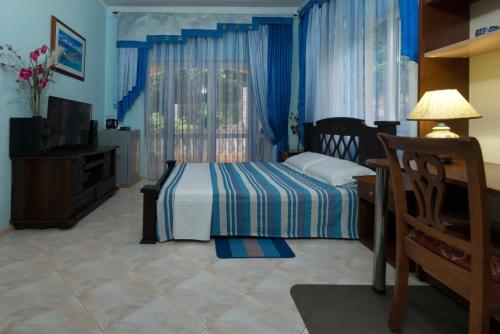 a bedroom with a bed and a dresser and a television at SeyBreeze Villa in Anse Royale