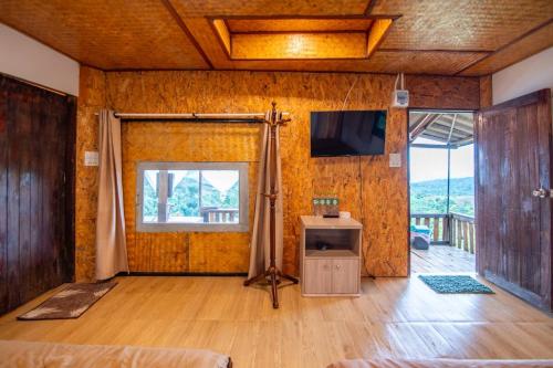 a living room with a tv and a wooden wall at บ้านลิ้นจี่โฮมสเตย์ Baan Lychee homestay in Ban Thung Phan Ha