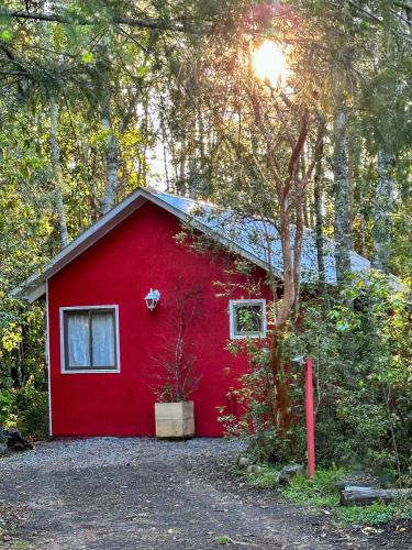 a red shed with a window and a tree at Molco Cabins Bosque in Pucón
