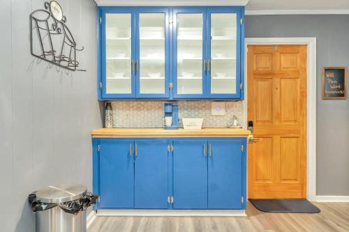 a kitchen with blue cabinets and a wooden door at Capital City Eagle's Nest - Pool Table - Pet Friendly - 6 beds in Montgomery