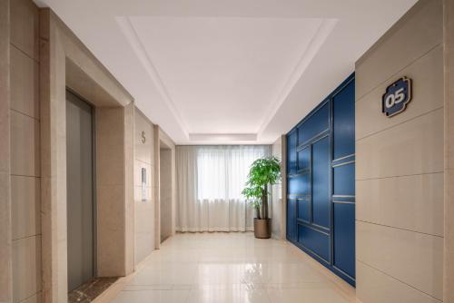 a hallway with a blue door and a potted plant at Holiday Inn Express Beijing Downtown by IHG in Beijing