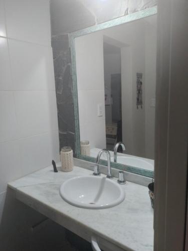 een badkamer met een wastafel en een grote spiegel bij Las Lavandas ´´Casa de Playa´´ in Playa Unión
