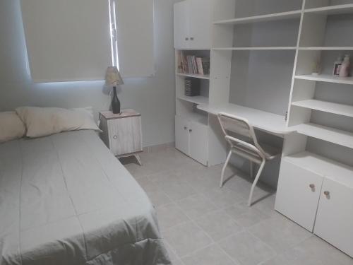 1 dormitorio con cama, escritorio y silla en Las Lavandas ´´Casa de Playa´´ en Playa Unión