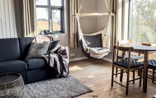 a living room with a blue couch and a hammock at Áskot Cottages in Hella