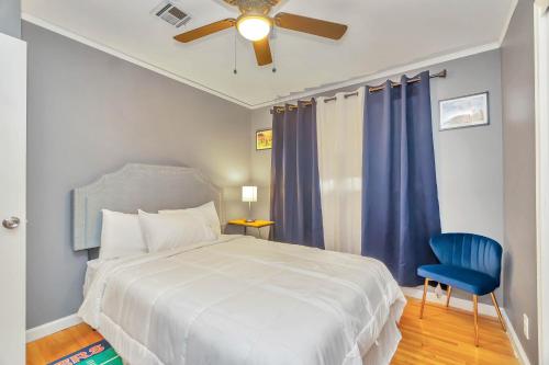 ein Schlafzimmer mit einem Bett und einem blauen Stuhl in der Unterkunft Capital City Eagle's Nest - Pool Table - Pet Friendly - 6 beds in Montgomery