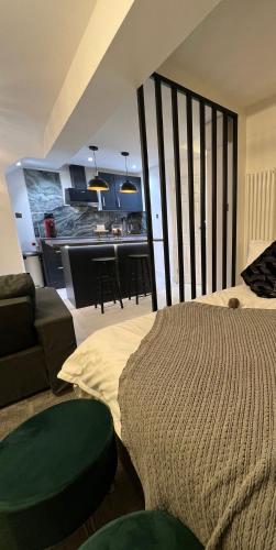 a room with a bed and a couch and a kitchen at Modern studio apartment in West Kensington in London