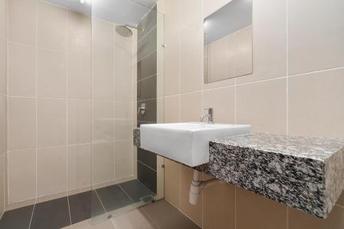 a white bathroom with a sink and a mirror at Medic Homestay Selayang Residence 280 in Batu Caves