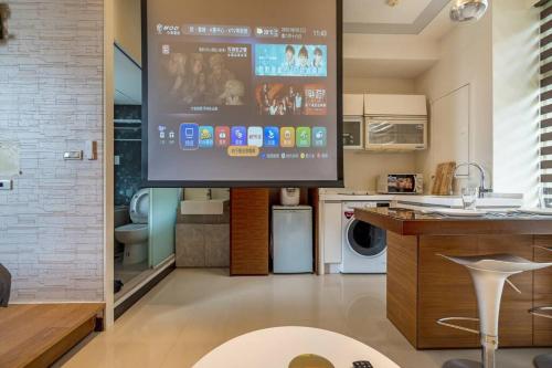 una sala de estar con una pantalla grande en la cocina en 1B1b Cinema, Kitchen, Bathtub, Desk, 1.5min to MRT • 1房1衛 家庭戲院、廚房、浴缸、書桌，1.5分到市府捷運, en Taipéi