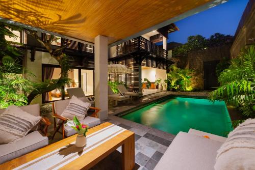an outdoor patio with a swimming pool in a villa at Adepa Resort in Canggu