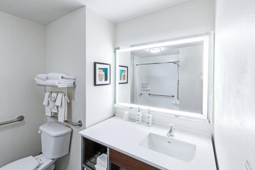 a white bathroom with a sink and a mirror at Holiday Inn Hotel & Suites Tulsa South by IHG in Tulsa